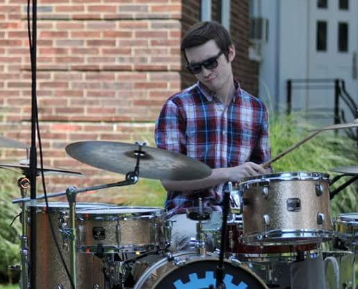 Greg playing drums on stage